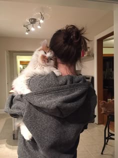 a woman holding a cat in her arms