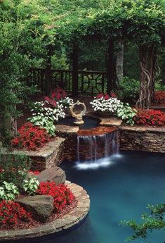 an outdoor pool surrounded by flowers and water features a waterfall that flows into the pond