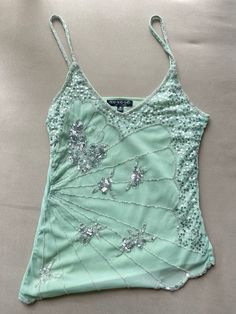 This rare vintage camisole is beautifully hand-beaded with a delicate butterfly-inspired design. The soft blush pink fabric is decorated with shimmering sequins and floral beadwork, giving it an elegant and unique look. With its light, airy feel and asymmetrical layers, this top is perfect for festival Y2k Embellished Top, Beaded Tanks, Beaded Fairy Top, Tops With Beads, Sequin Butterfly Top, Sparkle Tops, Bedazzled Top, Bejeweled Top, Mint Green Items