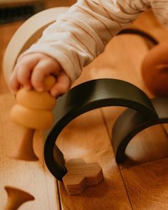 a toddler playing with wooden toys on the floor