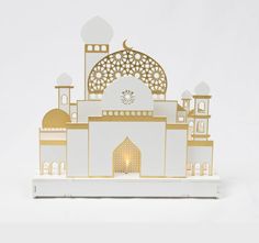 a white and gold building with a clock on it's front side, against a white background