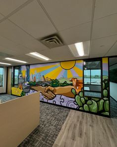 an empty office with a mural on the wall