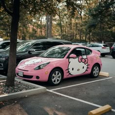 a pink hello kitty car parked in a parking lot