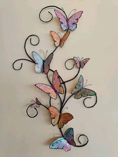 a metal wall hanging with butterflies on it