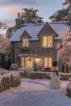 a snowman in front of a house with lights on and wreaths around the windows