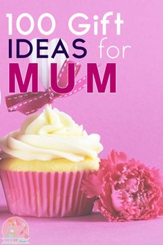 a cupcake with white frosting sitting next to a pink flower on a pink background