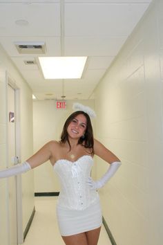 a woman in a white corset posing for the camera