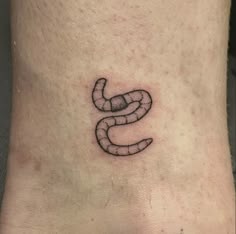 a black and white photo of a foot with a snake tattoo on it's side
