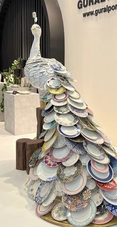 there is a very large peacock made out of plates