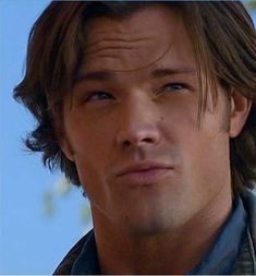 a close up of a person wearing a jacket and looking at the camera with a serious look on his face