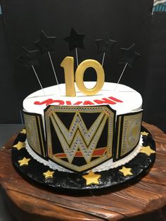 a birthday cake with the number ten on top and stars around it is sitting on a wooden table