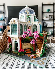 a doll house made out of legos with flowers on the front and side windows