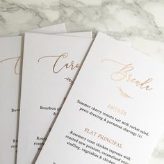 three menu cards with gold lettering on them