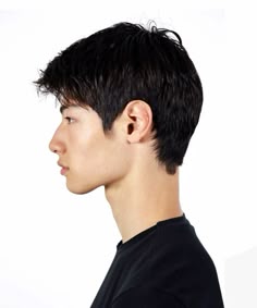 a young man with black hair is looking off to the side