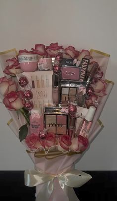 a bouquet of pink roses and cosmetics in a vase