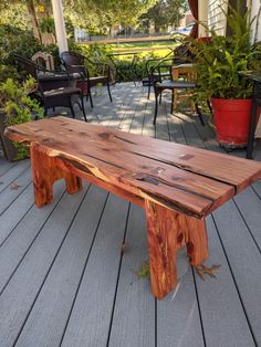 a wooden bench sitting on top of a wooden deck next to potted planters