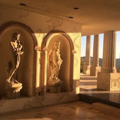 statues in the middle of a room with columns and arches on either side of them