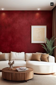 a living room with red walls, white furniture and a round coffee table in the middle
