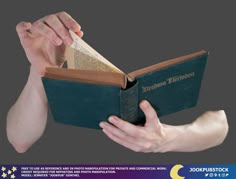 a person is holding an open book in their left hand and reaching out to touch it