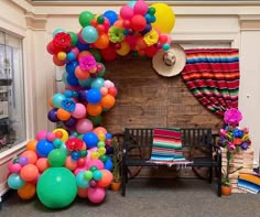 a bunch of balloons that are in front of a fire place with a bench next to it
