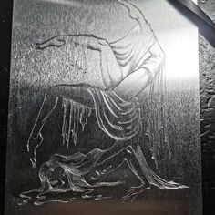 a metal plaque with a drawing of a woman kneeling down on the ground next to a knife