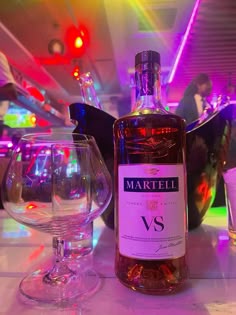 a bottle of wine and two glasses on a table