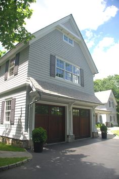 a large white house with two brown garage doors