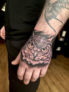 an owl tattoo on the left hand