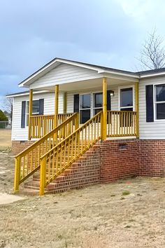 a small white house with yellow stairs leading up to it