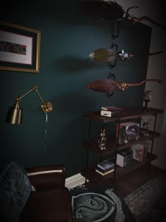a living room with dark green walls and wooden flooring, two lamps hanging from the ceiling