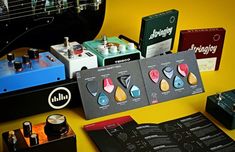 an assortment of musical instruments are displayed on a yellow table with black and white background