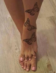 a woman's foot with butterfly tattoos on her left leg and the bottom part of her legs
