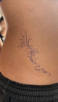 a woman's lower back tattoo with flowers on it