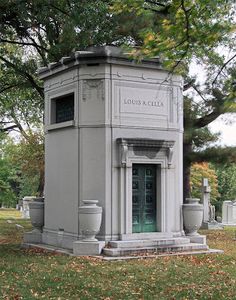 a monument in the middle of a cemetery with urns on it's sides