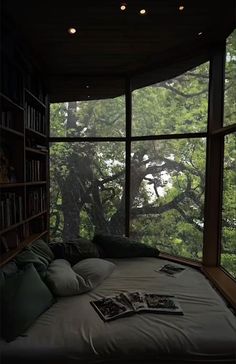 there is a bed in the room with many pillows on it and bookshelves