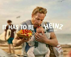 a man holding a baby in his arms with the words, it has to be heinzz