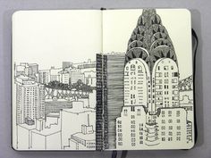 an open notebook with a drawing of a city
