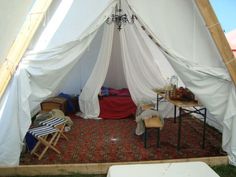 the inside of a tent that is set up with chairs and tables in front of it