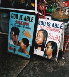 two signs advertising hairdressers on the sidewalk