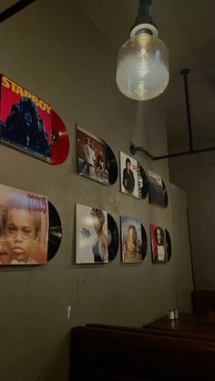there are many records on the wall and one is hanging from the light fixture above