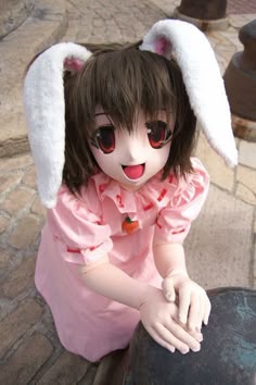 a doll with bunny ears sitting on top of a table