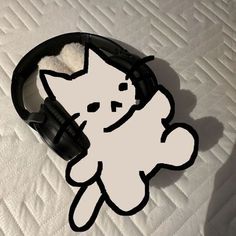a white cat with black headphones on top of a bed