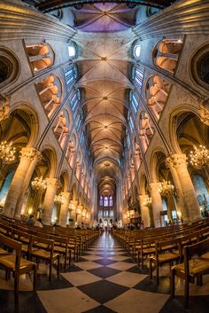 the inside of a church with pews and chandeliers on either side of it