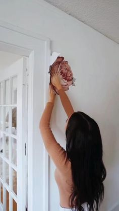 a woman is holding a flower on the wall