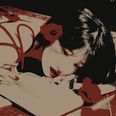 a woman laying on top of a bed next to an open book and writing in a notebook