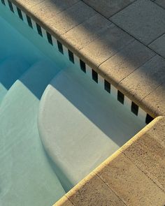 an empty swimming pool with concrete steps and tiled walls around the edge, as seen from above
