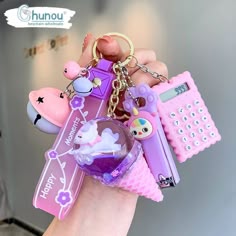 a hand holding a keychain with various items on it