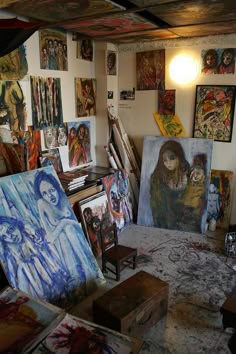 an artist's studio with many paintings on the walls