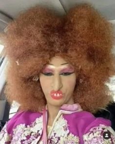 a mannequin with red hair in a car wearing a purple outfit and pink lipstick