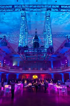 a large room filled with lots of tables and chairs under a blue sky covered in clouds